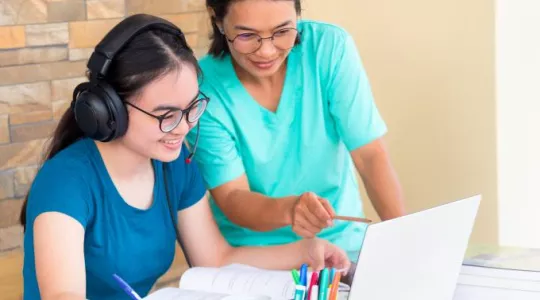 Mother and daughter using laptop