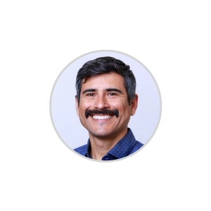 A man smiling with a blue shirt